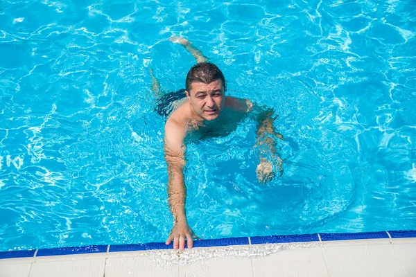 Retrato de hombre joven relajándose en la piscina, verano al aire libre — Foto de Stock