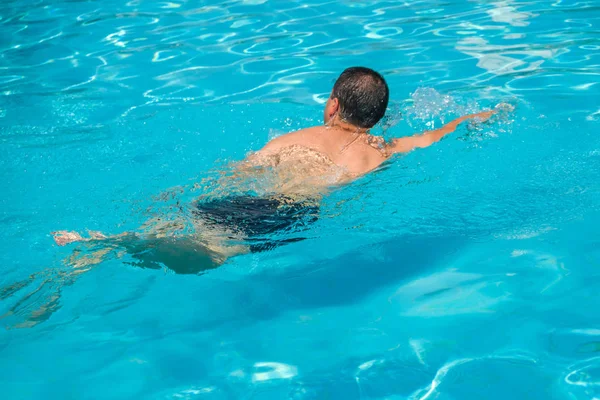 Porträtt av ung man koppla av i poolen, sommar utomhus — Stockfoto