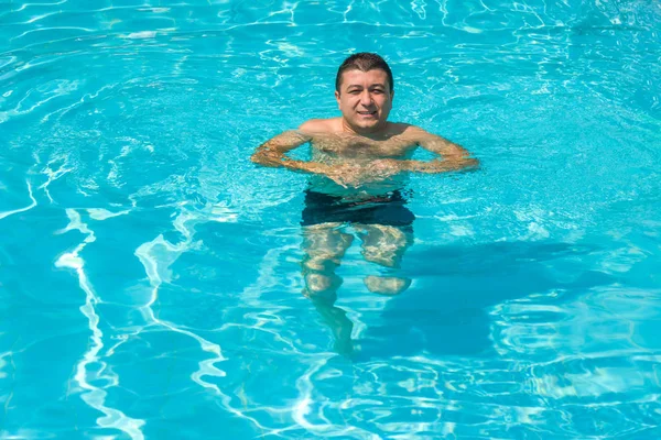 Porträtt av ung man koppla av i poolen, sommar utomhus — Stockfoto