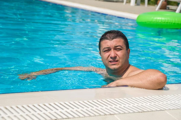 Портрет молодого человека, отдыхающего в бассейне, летний открытый — стоковое фото