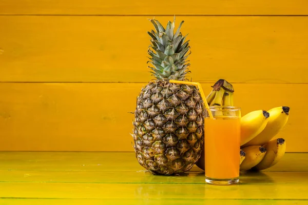 Тропічні фрукти на жовтому дерев'яному фоні, свіжа їжа — стокове фото