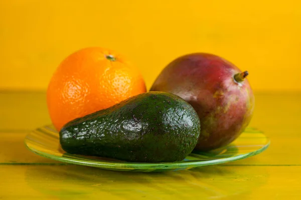 黄色の木製の背景にテーブルの上の熱帯性果物 — ストック写真