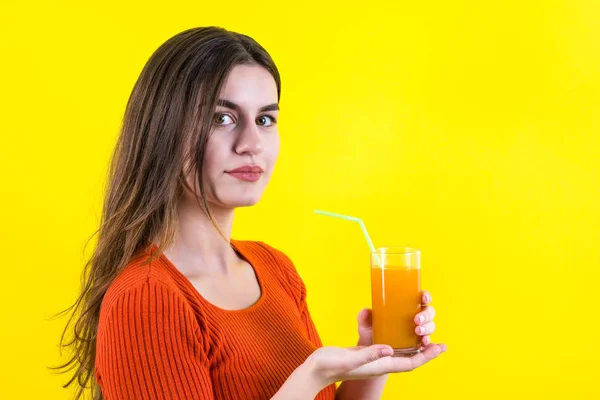 Bella ragazza adolescente felice con succo d'arancia giallo su giallo — Foto Stock