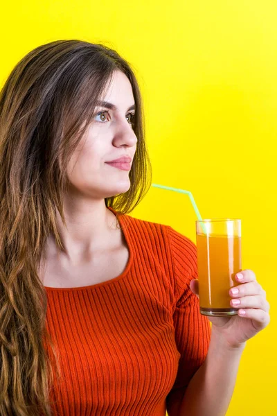 Bella ragazza adolescente felice con succo d'arancia giallo su giallo — Foto Stock