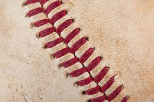 Vista ravvicinata macro di cuciture rosse cucite di una palla da baseball usurata — Foto Stock