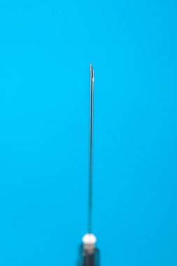 Tıbbi iğne, üzerinde mavi arka plan izole. Nesne