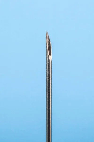 Medical needle, isolated on blue background. Object