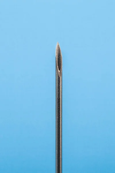 Medical needle, isolated on blue background. Object