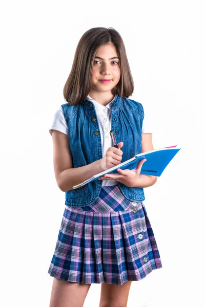 Vacker flicka i skoluniform med en anteckningsbok i hennes hand på — Stockfoto