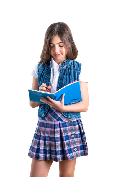 Belle fille en uniforme scolaire avec un cahier à la main sur — Photo