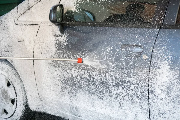 Processo de lavagem de carro de luxo carro cheio coberto com espuma branca um — Fotografia de Stock