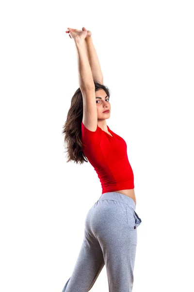 stock image beautiful brunette teenager in red shirt is exercising, white ba