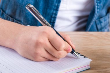 Çocuğun el holding kalem. Bir not içinde mektup yazma çocuk