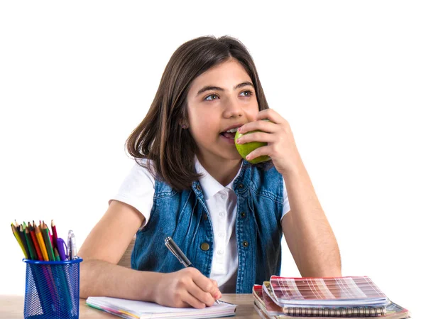 Een prachtige school meisje zit aan de balie met appel en denken — Stockfoto