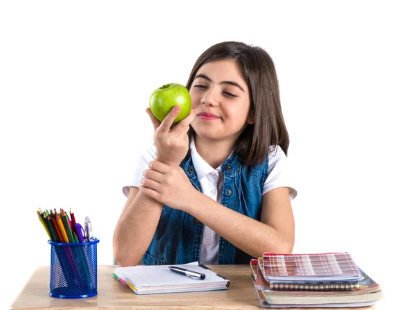 Een prachtige school meisje zit aan de balie met appel en denken — Stockfoto