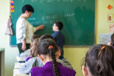 Okul çocukları sınıfta aktif olarak katılıyor. Ders