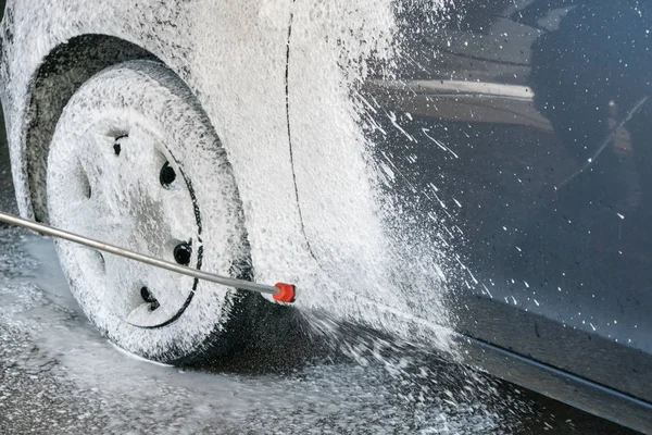 Processo de lavagem de carro de luxo carro cheio coberto com espuma branca um — Fotografia de Stock