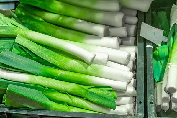 Manojo de puerro orgánico fresco en la estantería en un mercado . —  Fotos de Stock