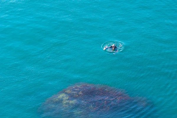 Pescador buceador pescando en el Mar Negro. La superficie de puro se — Foto de Stock