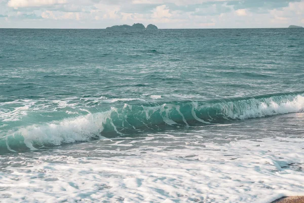 Gyönyörű tenger fröccsenő hullám a tengerparton. Tengeri sügér. — Stock Fotó