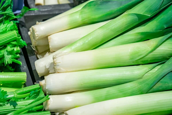 Manojo de puerro orgánico fresco en la estantería en un mercado . —  Fotos de Stock