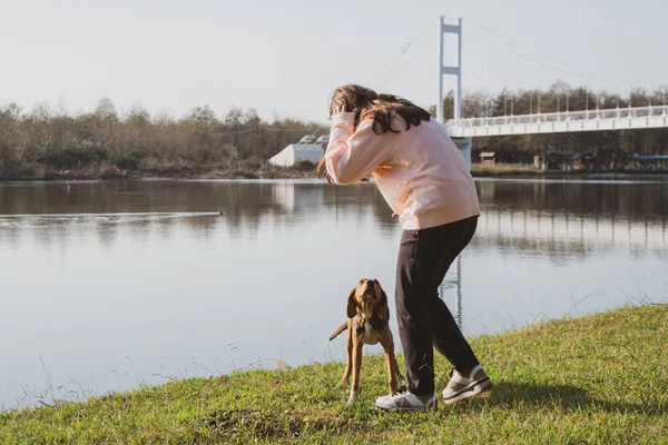 Девушка ласкает брошенную собаку на озере. Усыновление животных. Поти — стоковое фото