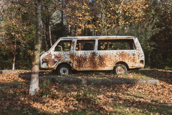 Old abandoned rusty car in a park. — Stock Photo, Image