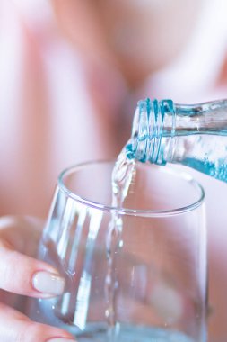 Şişeden taze su döken kadının eli..