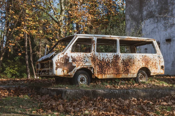 Old abandoned rusty car in a park. — Stock Photo, Image