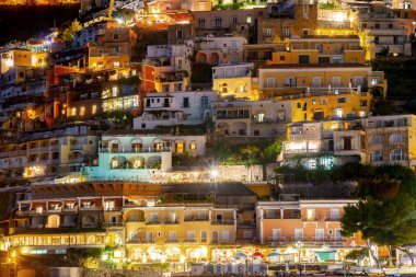 Positano 'nun renkli evleri gece Amalfi kıyısı boyunca, İtalya.