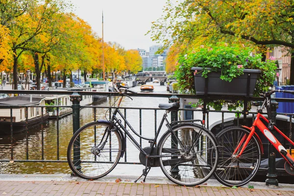 Fietsen op een brug over de grachten van Amsterdam. Kleurrijke huisjes — Stockfoto