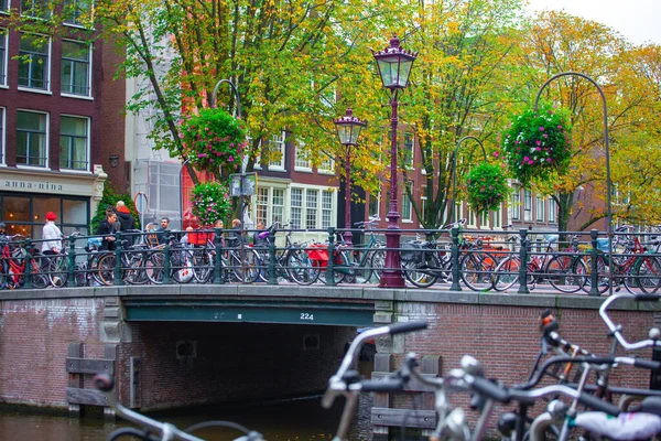 Amsterdam, Nederland - 16.10.2019: Amsterdams kanaal met fietsen op brug. — Stockfoto