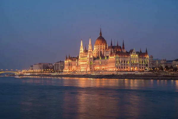 Edificio del Parlamento húngaro y río Danubio en la ciudad de Budapest por la noche. Una muestra de arquitectura neogótica . — Foto de Stock