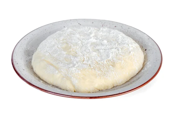 Сире тісто лежить на тарілці на білому тлі . — стокове фото