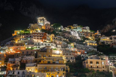 Positano 'nun renkli evleri gece Amalfi kıyısı boyunca, İtalya. Gece manzarası.
