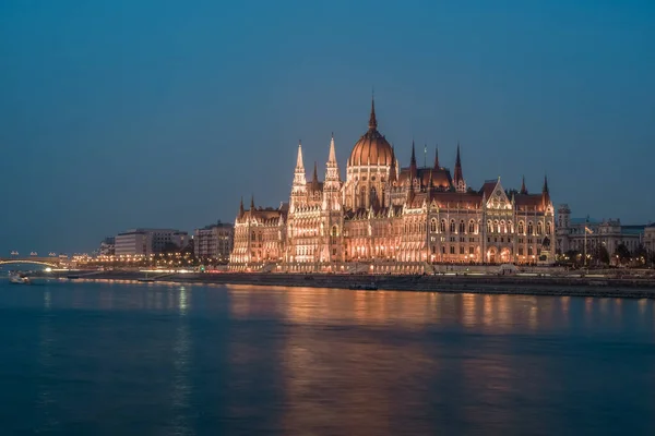 Edificio del Parlamento húngaro y río Danubio en la ciudad de Budapest por la noche. Una muestra de arquitectura neogótica . — Foto de Stock