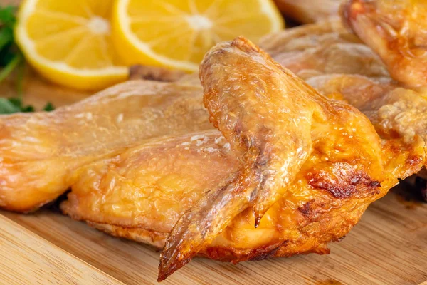 Fried chicken on a wooden bord with lemon. — Stock Photo, Image