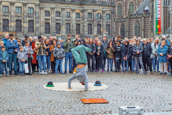Amsterdam, Netherlands - 14.10.2019: Street acrobat on the Dam Square