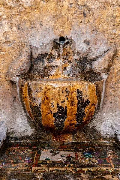 Water flowing from a faucet of a stone fountain — Stock Photo, Image