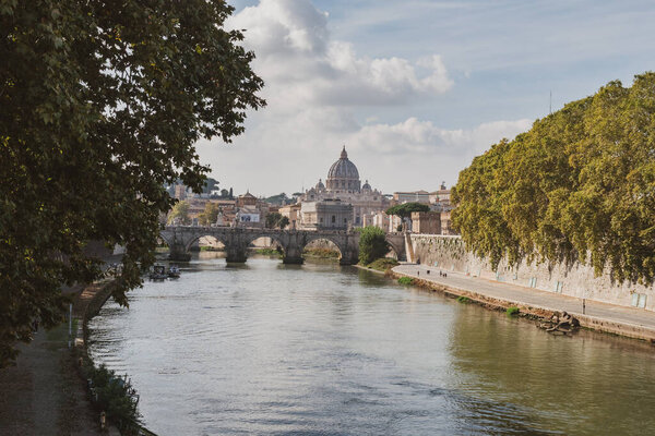 St. Peter's cathedral over bridge and Tiber river water at autumn day Rome