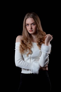 Blonde model with blue eyes over black background.