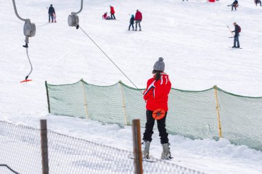 Skiers skiing climb a yoke on a mountain. Light skiing track in Bakuriani