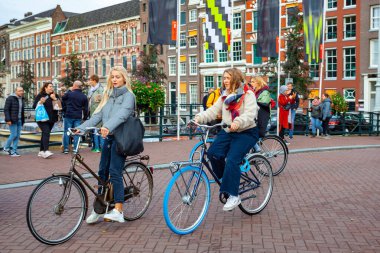 Amsterdam, Hollanda - 14 Ekim 2019: Amsterdam 'ın tarihi bölümünde bisiklete binen insanlar. Seyahat