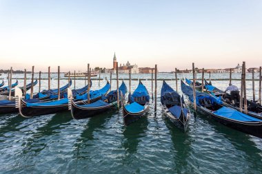 Venedik 'teki San Giorgio di Maggiore kilisesi ile Saint Mark Meydanı' na demirlemiş Gondollar İtalya 'da seyahat ediyor.