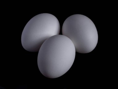 Siyah arka planda beyaz organik tavuk yumurtaları, yiyecek.