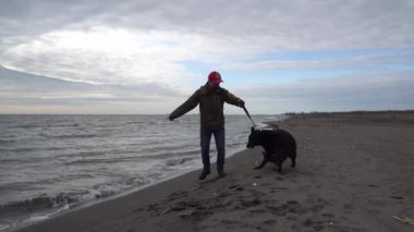 Alman çoban köpeği ve sahibi Karadeniz, Poti, Gürcistan kıyılarında yürürler.