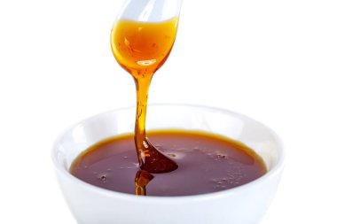 Bal seramik kaşıktan seramik kaseye ve yiyeceğe damlıyor.