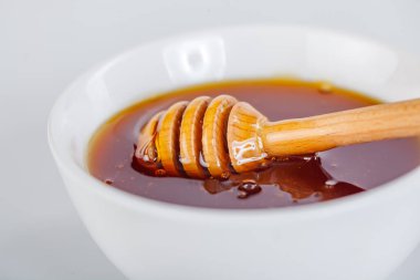 Ballı ve yiyecekli seramik kaseye ahşap kaplama.