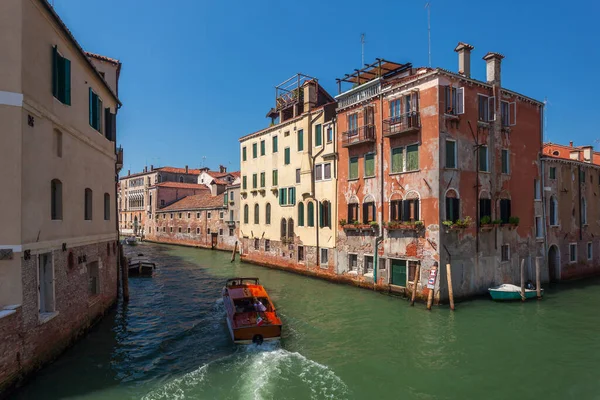 View of narrow Canal with boats and gondolas in Venice, Italy. Venice is a popular tourist destination of Europe