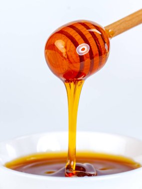 Bal damlıyor ahşap kaptan seramik kaseye, yiyeceğe